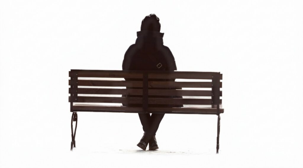 سایه مرد تنها که روی نیمکت نشسته و از جامعه فاصله گرفته، نماد انزوای ناشی از نامشروع بودن سوگ.