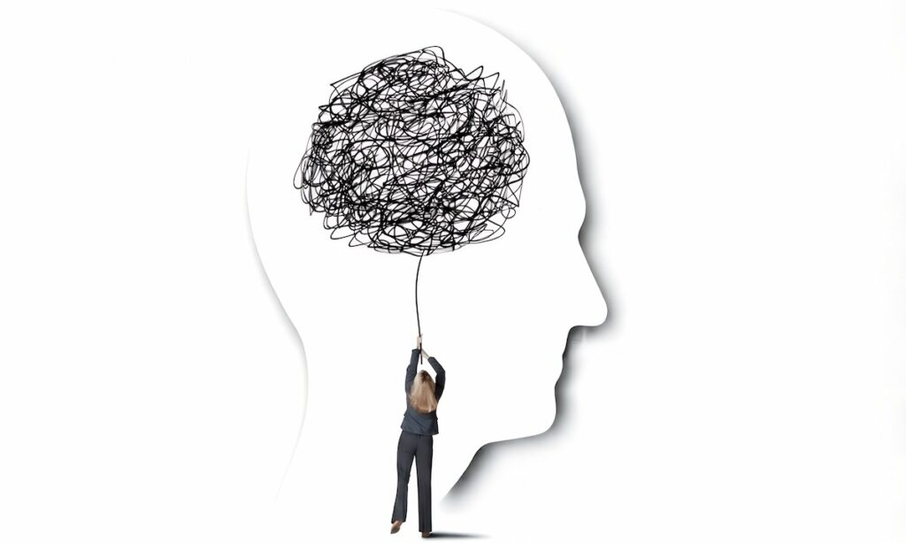 تصویر مفهومی از زنی که رشته‌ی افکار آشفته و درهم‌پیچیده را در داخل نیم‌رخ ذهن انسان در دست دارد؛ نمادی از چگونگی شکل‌گیری فاجعه‌سازی و سناریوهای ترسناک در مغز.