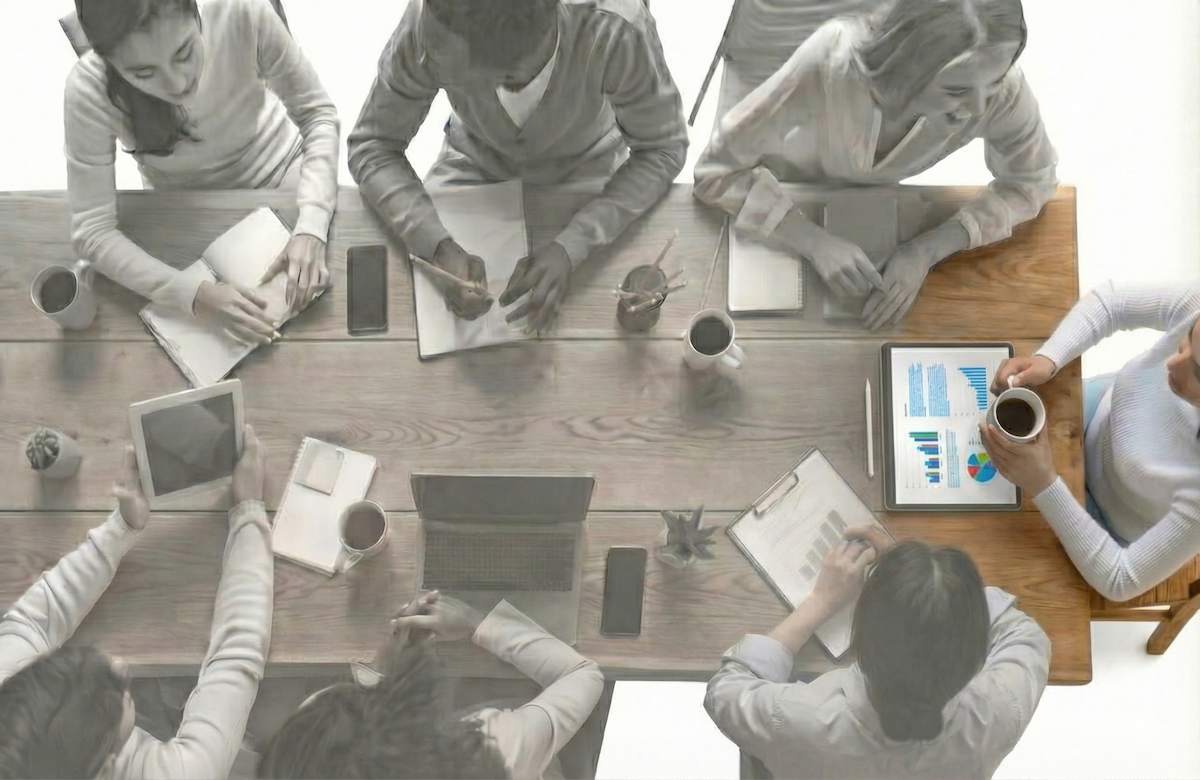 جای خالی تیم کاری در حال همکاری و همفکری دور یک میز؛ نمادی از «اثر ضربه‌گیر اجتماعی» و حمایت گروهی که استرس محیط کار را کاهش می‌دهد و فریلنسرها از آن محروم هستند.