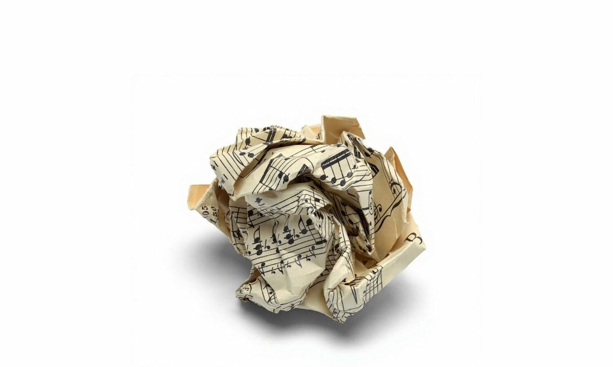 تصویری از یک کاغذ نت موسیقی قدیمی و مچاله شده، که نمادی است از یک سمفونی ناتمام، رویاهای رها شده و پایان‌های ناگهانی.