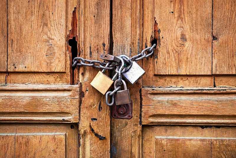 تصویر مفهومی از یک درب بسته با قفل‌های متعدد. استعاره‌ای از دیوارهای دفاعی و اضطراب طرد شدن در روابط عاطفی.