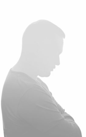 سیلوئت محو و خاکستری مردی که دست به سینه ایستاده و به پایین نگاه می‌کند، نمادی از ریشه‌های فرد خاکستری و عدم دسترسی عاطفی در رابطه.