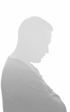 سیلوئت محو و خاکستری مردی که دست به سینه ایستاده و به پایین نگاه می‌کند، نمادی از ریشه‌های فرد خاکستری و عدم دسترسی عاطفی در رابطه.